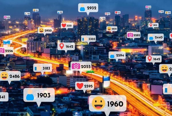 Photo of a city at night with chat bubbles with icons with a number representing interactions