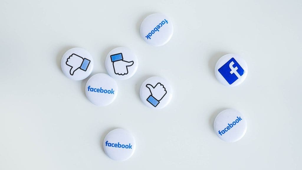 Photo of physical pins with the facebook logo and the like icon