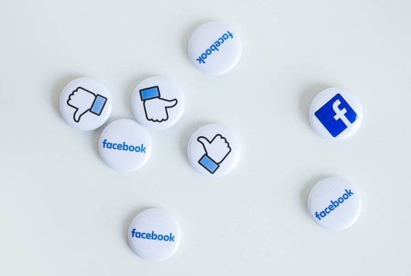 Photo of physical pins with the facebook logo and the like icon