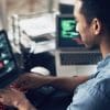 Man typing on laptop while looking at analytics dashboard